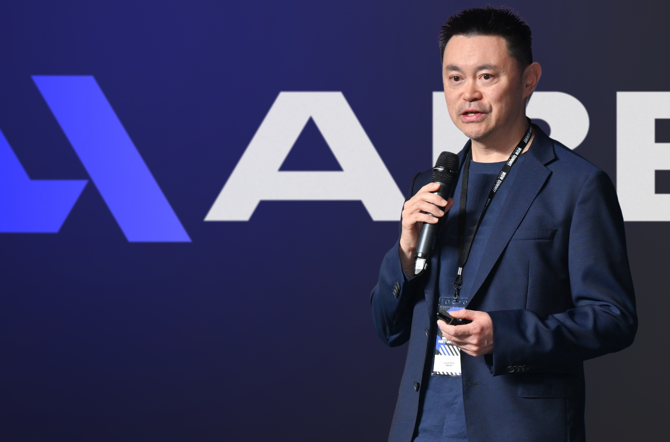 Two women sitting at a modern table talking with a city view behind them.